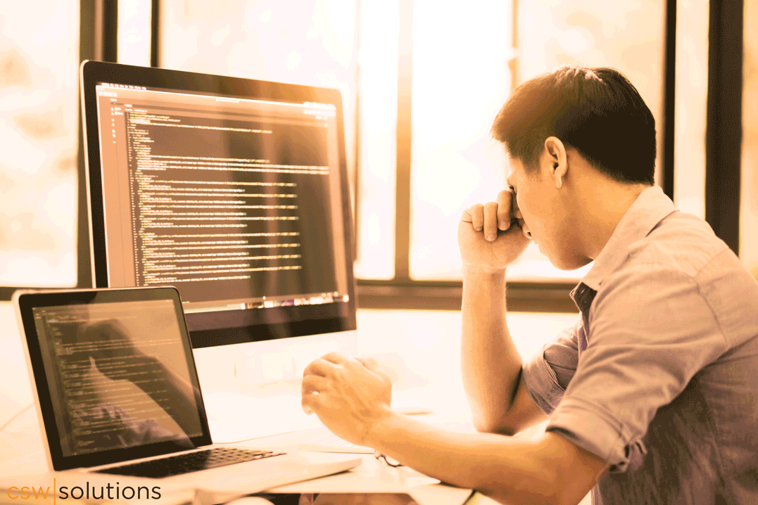 Frustrated man in front of code on pc