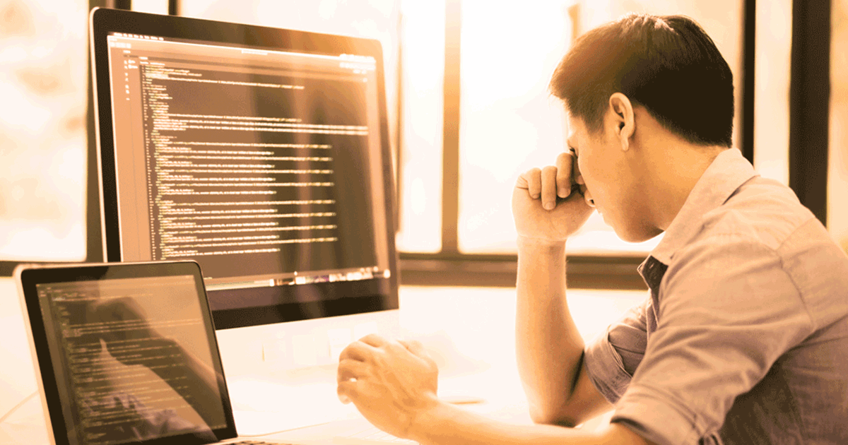Frustrated man in front of code on pc