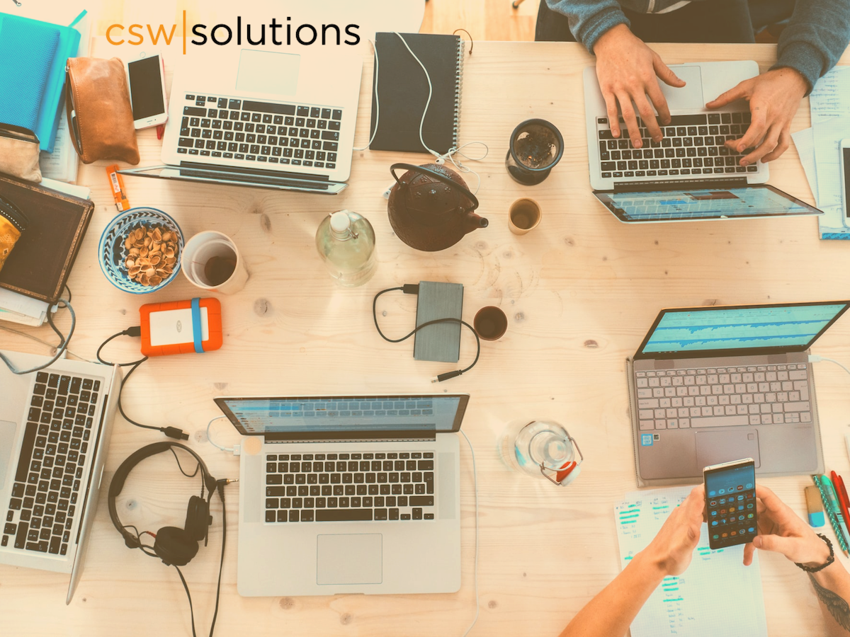 Top view of tabletop with laptops with accessories and people working