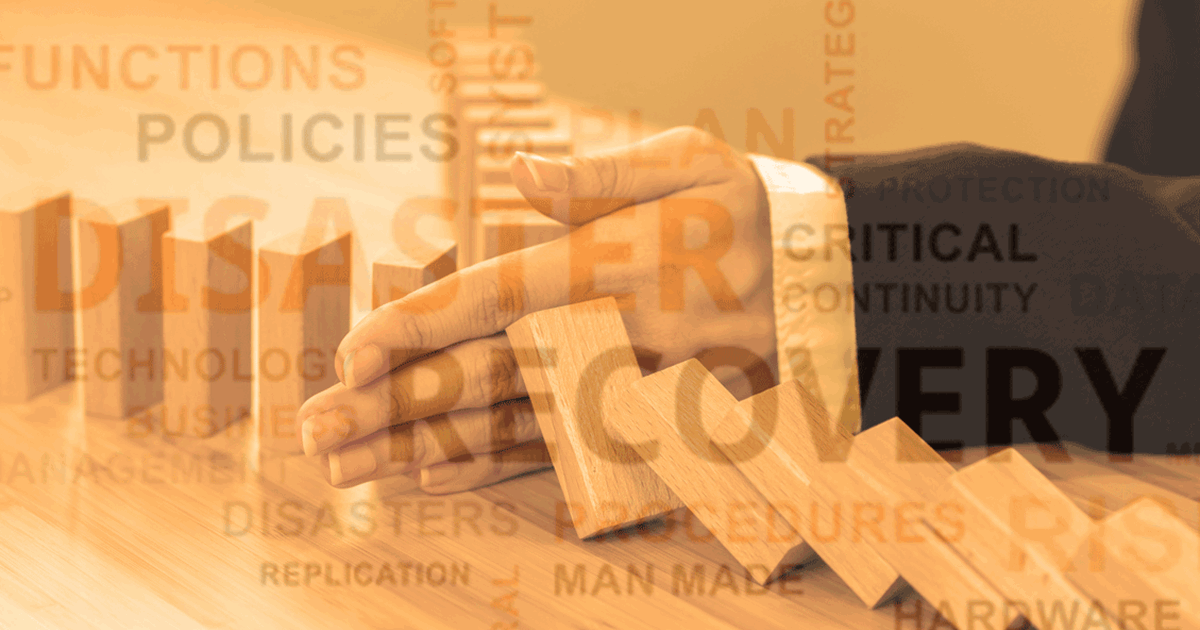Hand stopping domino blocks representing disaster recovery