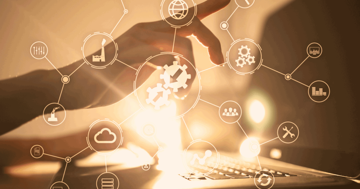 integration systems depicted with a hand behind multiple icons by a laptop
